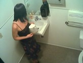 Hidden camera catches woman pissing in coffee pot.
